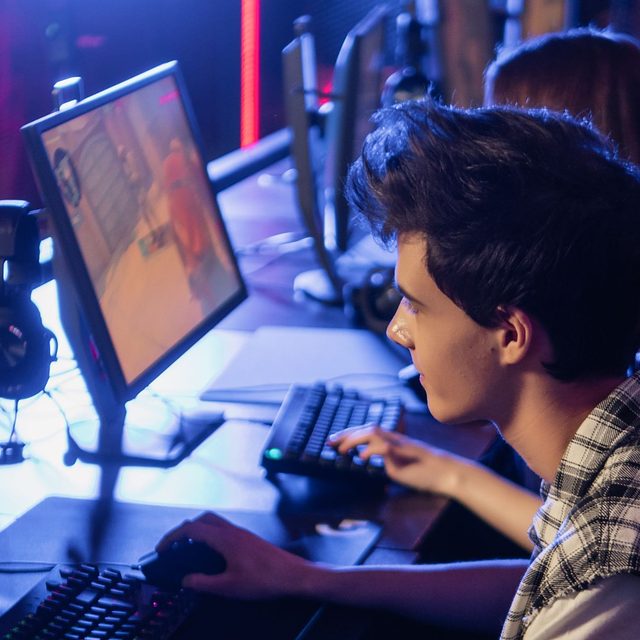 A young gamer at a lit-up PC